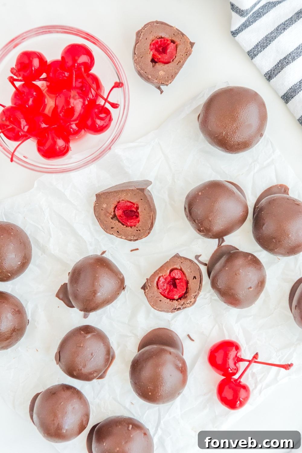 Cherry Brownie Bombs on a table with a side bowl of fresh cherries