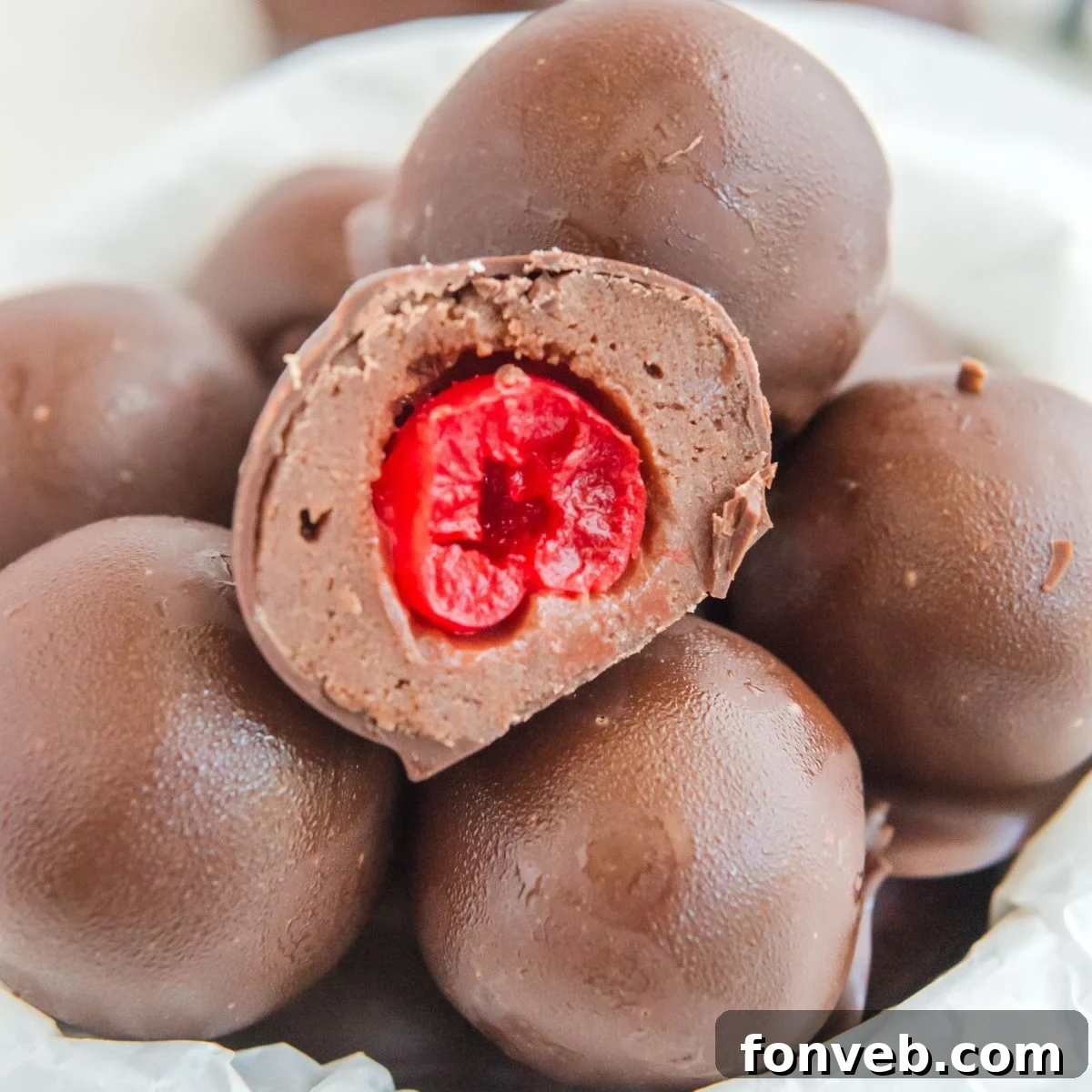 A bowl of Cherry Brownie Bombs with one cut open to reveal the cherry filling