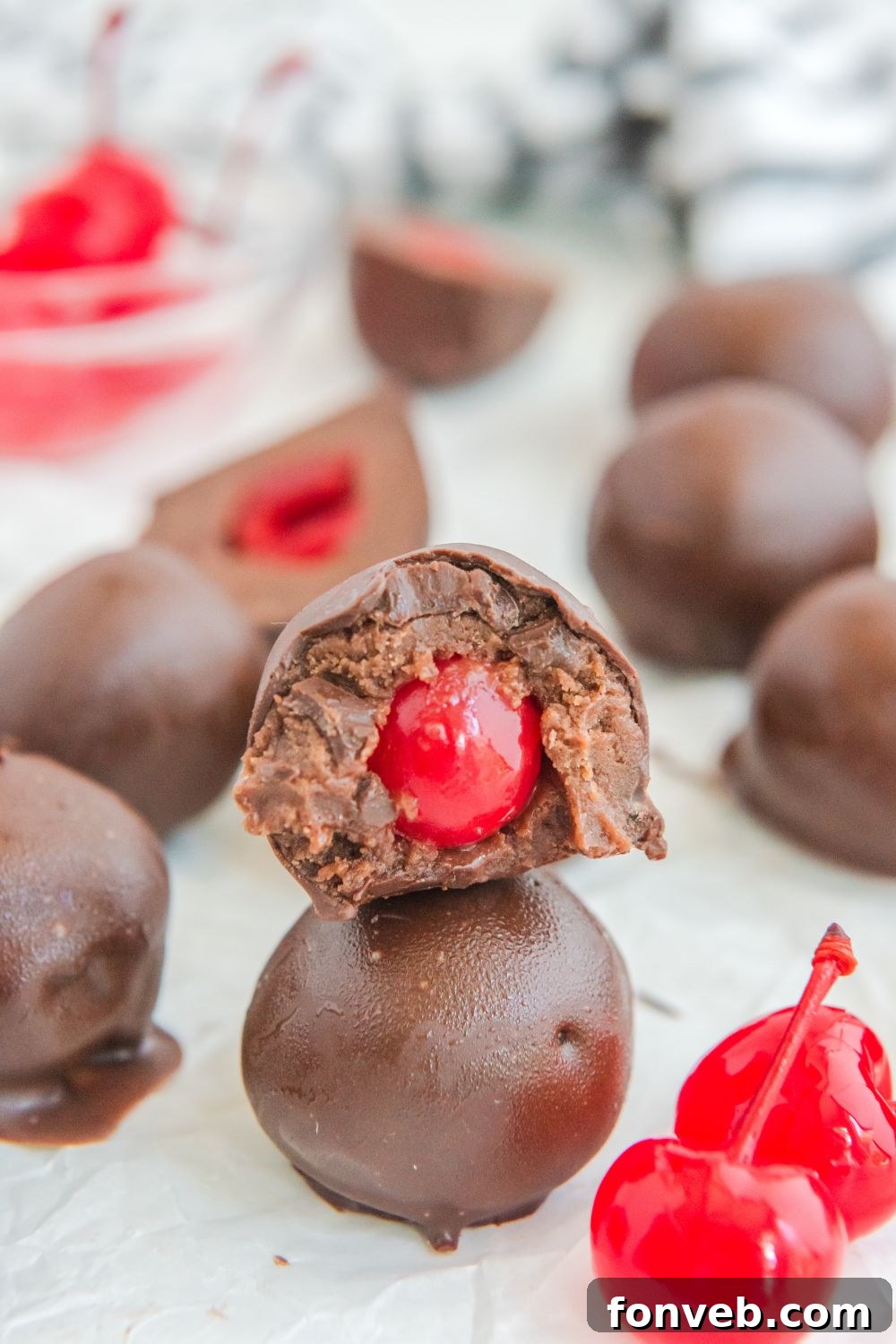 A close-up shot of Cherry Brownie Bombs, highlighting their smooth chocolate coating and festive appearance