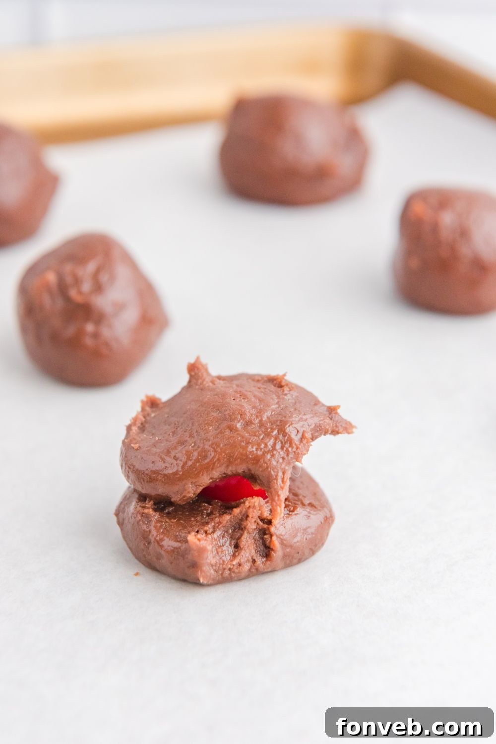 A single brownie ball with a maraschino cherry perfectly nestled in its center