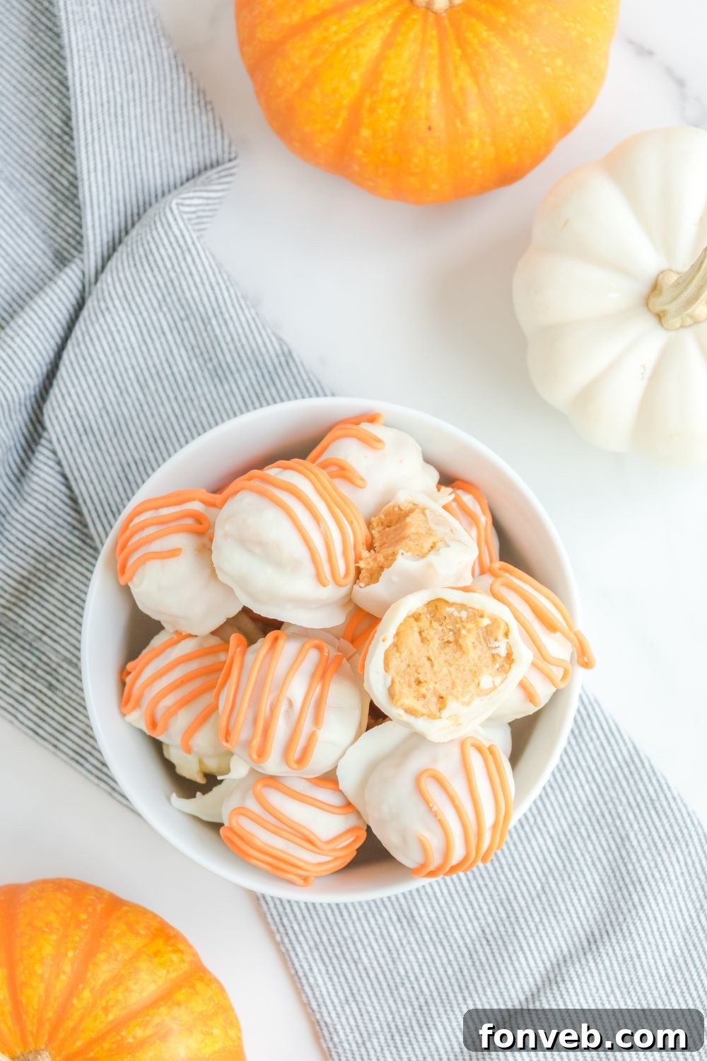 A bowl filled with various pumpkin dessert balls, showcasing a tempting array of fall treats.