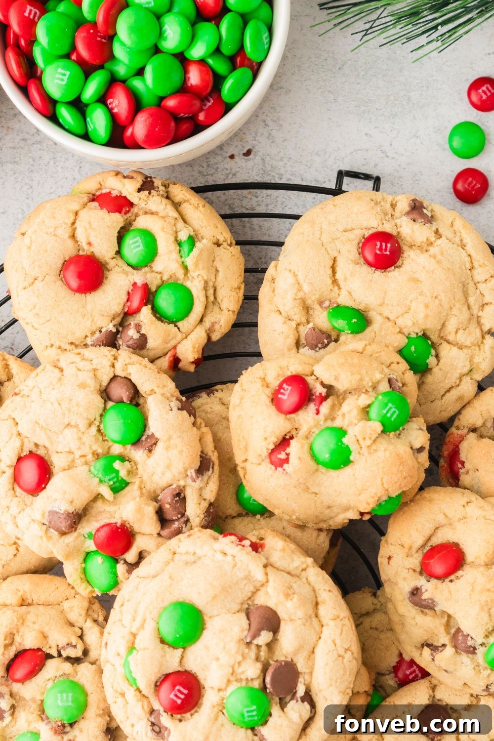 Festive M&M Delights 11 Holiday M&M cookies resting on a parchment-lined baking sheet, with a bowl of M&Ms on the side, ready for baking
