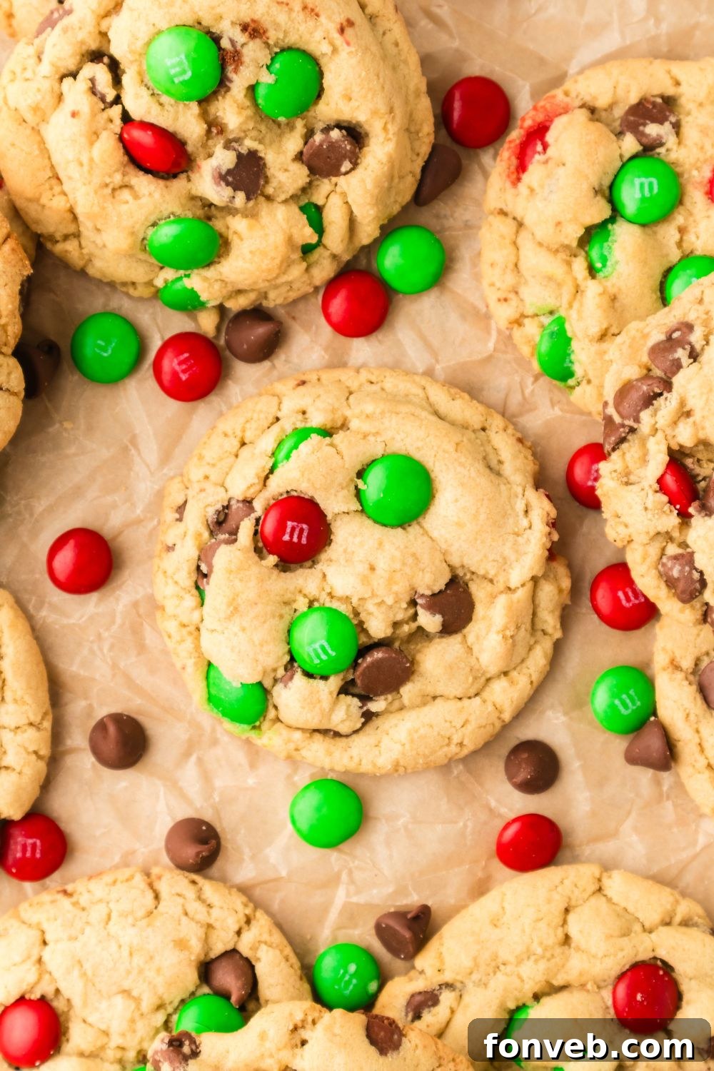 Festive M&M Delights 15 Freshly baked M&M cookies cooling on parchment paper on a table, with loose M&Ms scattered nearby, highlighting their festive appeal