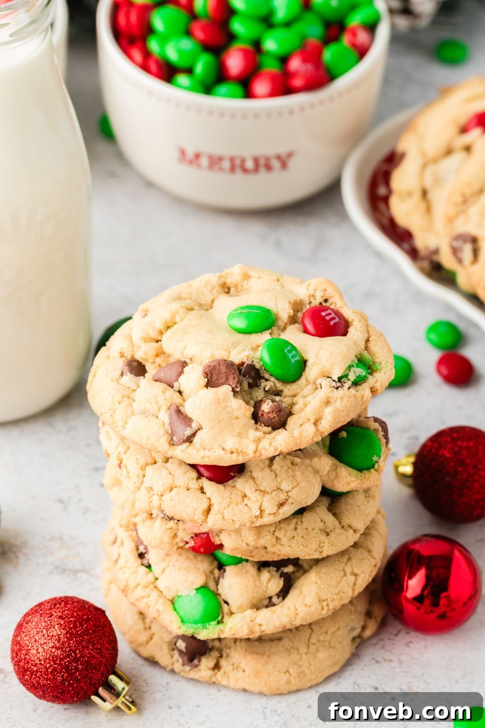 Festive M&M Delights 19 A charming stack of Christmas M&M cookies on a table, accompanied by a jar of milk, perfect for a cozy holiday treat