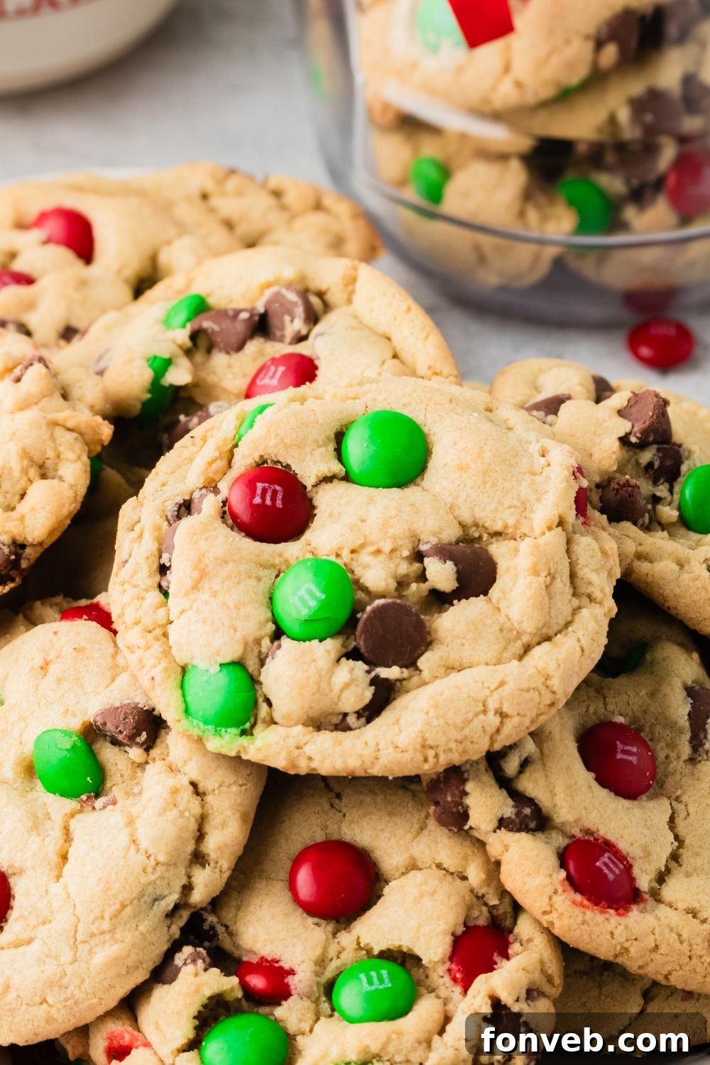 Festive M&M Delights 20 A festive stack of Christmas M&M cookies on a tabletop, showcasing their cheerful holiday colors and appealing texture