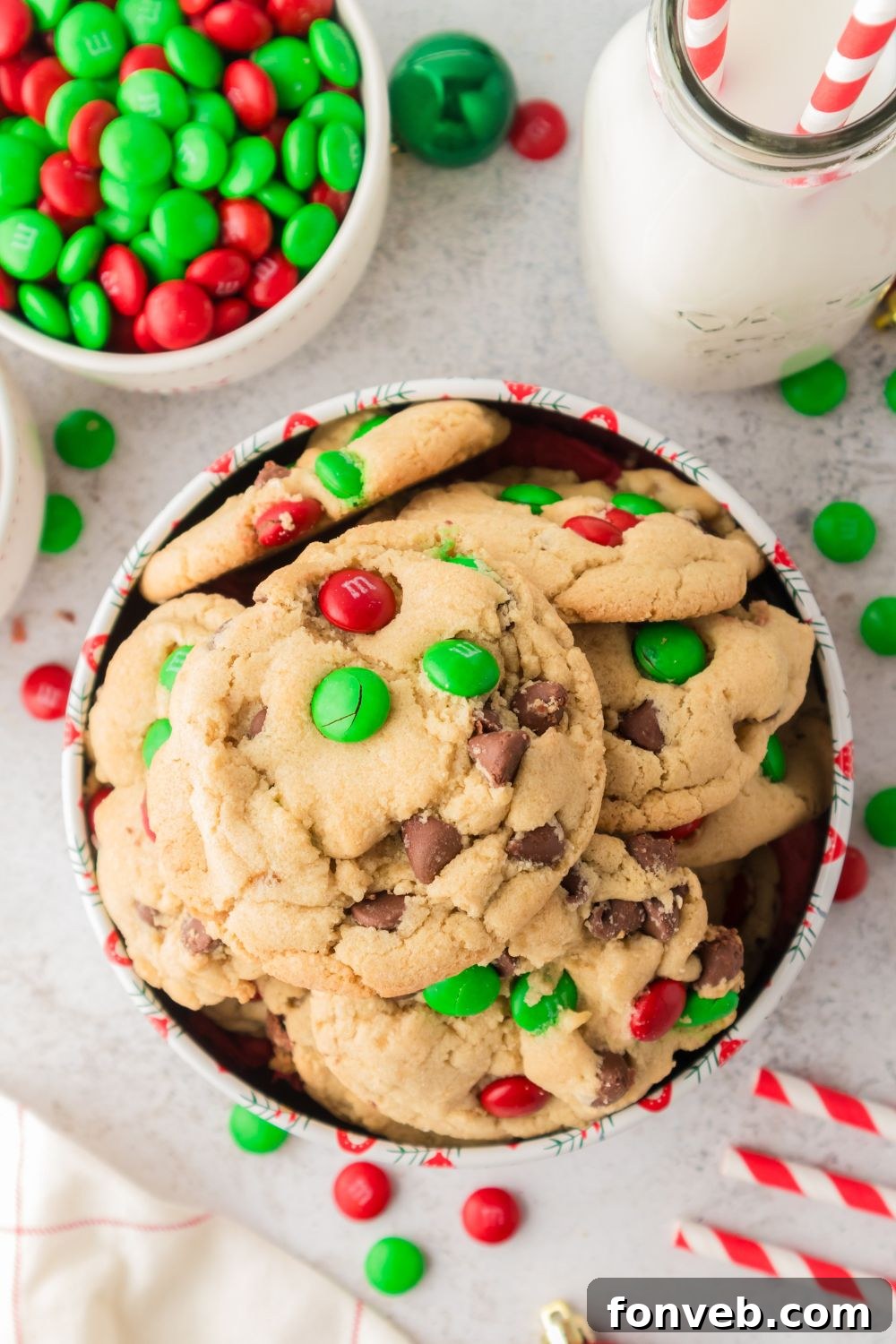 Festive M&M Delights 22 Christmas M&M cookies arranged in a festive tin, surrounded by loose M&Ms, creating a vibrant and appealing holiday display