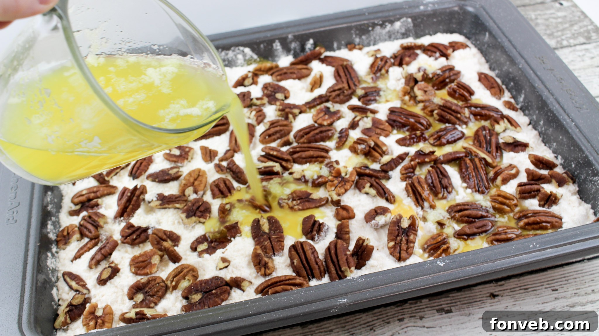 Easy Pumpkin Pecan Dump Cake 9 Melted butter being poured over the pecan and cake mix layers