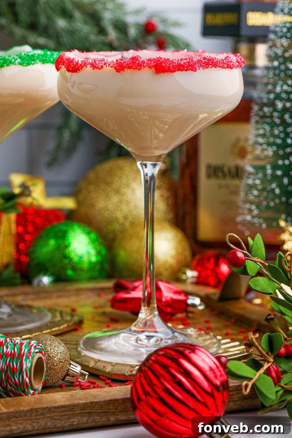 A festive Amaretto cocktail served in a glass on a wooden table, featuring a beautiful sugar rim and garnishes.