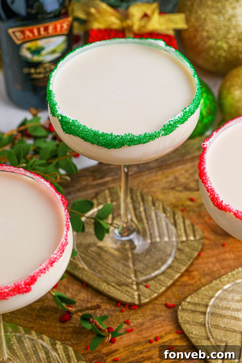A festive spread of Baileys Christmas cocktails, served in glasses with colorful sugar rims, arranged on a wooden table for a holiday gathering.