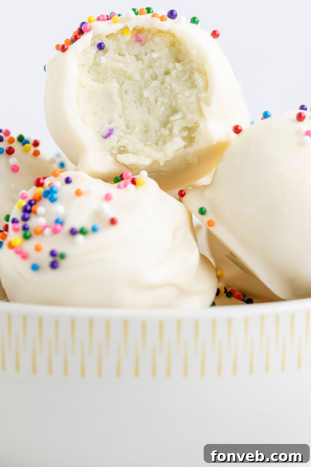 Sugar Cookie Truffles in a white bowl with a bite taken out of it 