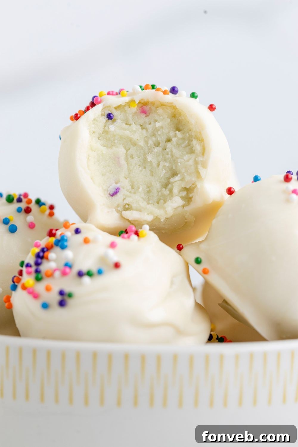 Truffles in a bowl with one that has a bite taken out of it 