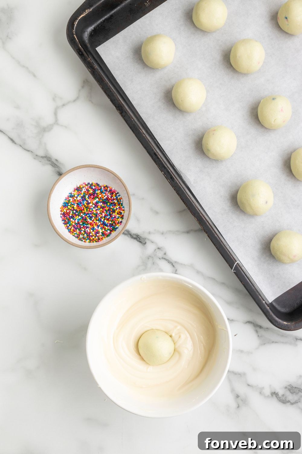 truffles on baking sheet with melted chocolate in a bowl on side 