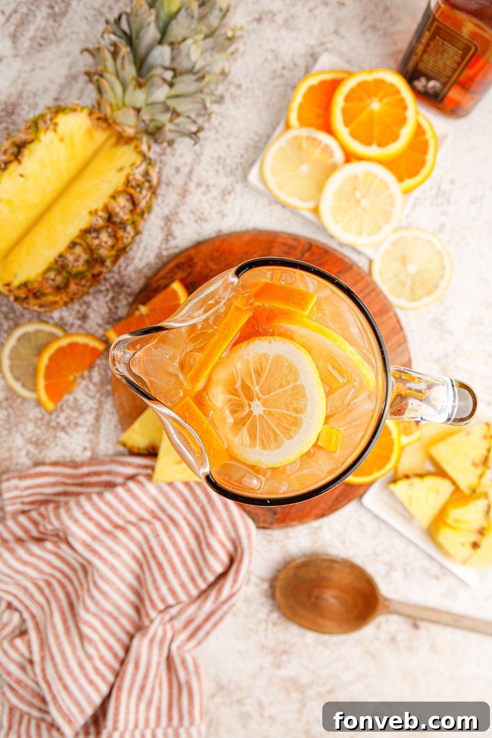 Endzone Chill 8 Sweet tea with bourbon in a serving pitcher, surrounded by various fruits.