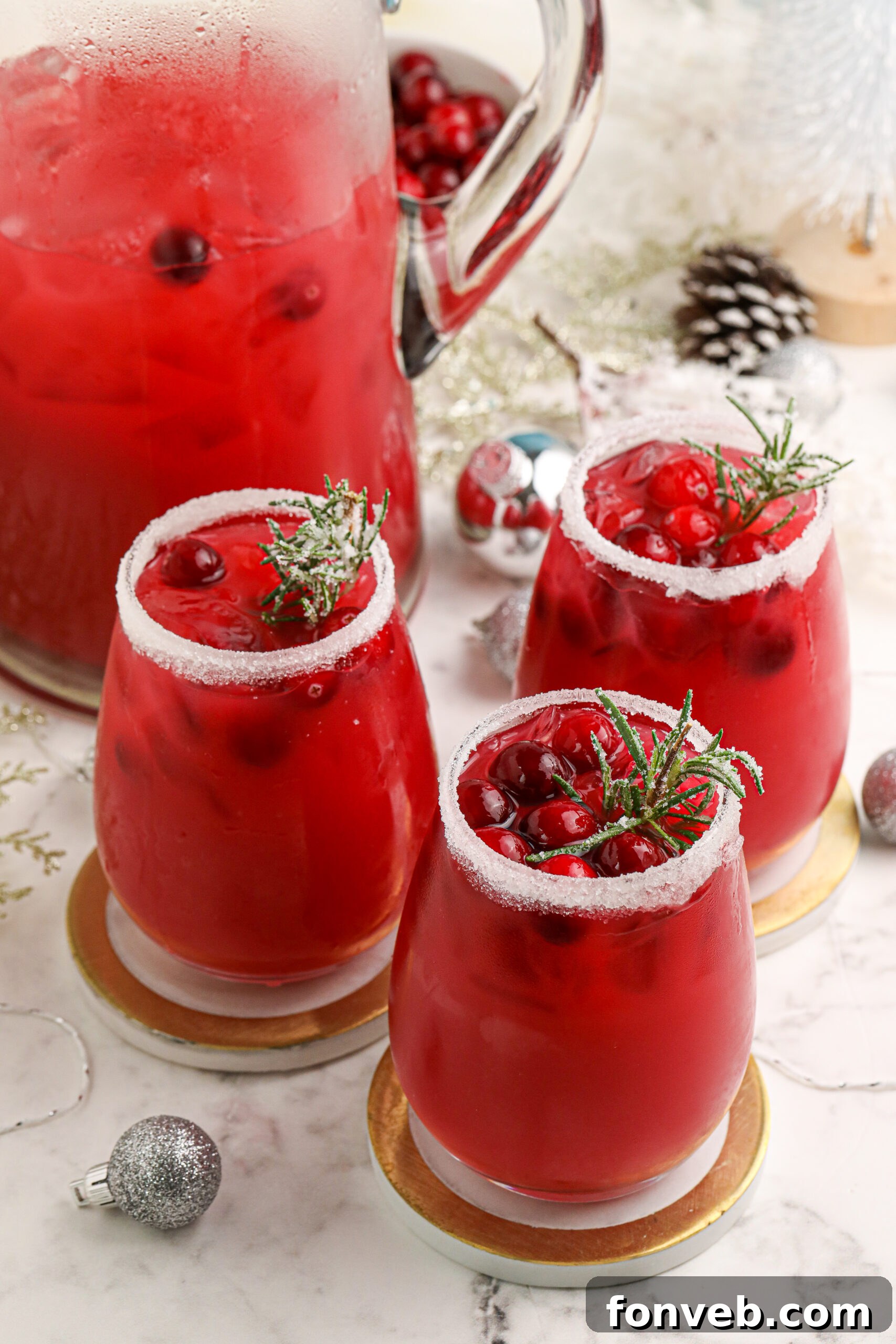 Mistletoe Magic Margarita 2 A beautifully presented Mistletoe Margarita, showcasing its rich red color and festive garnishes of rosemary and cranberries.