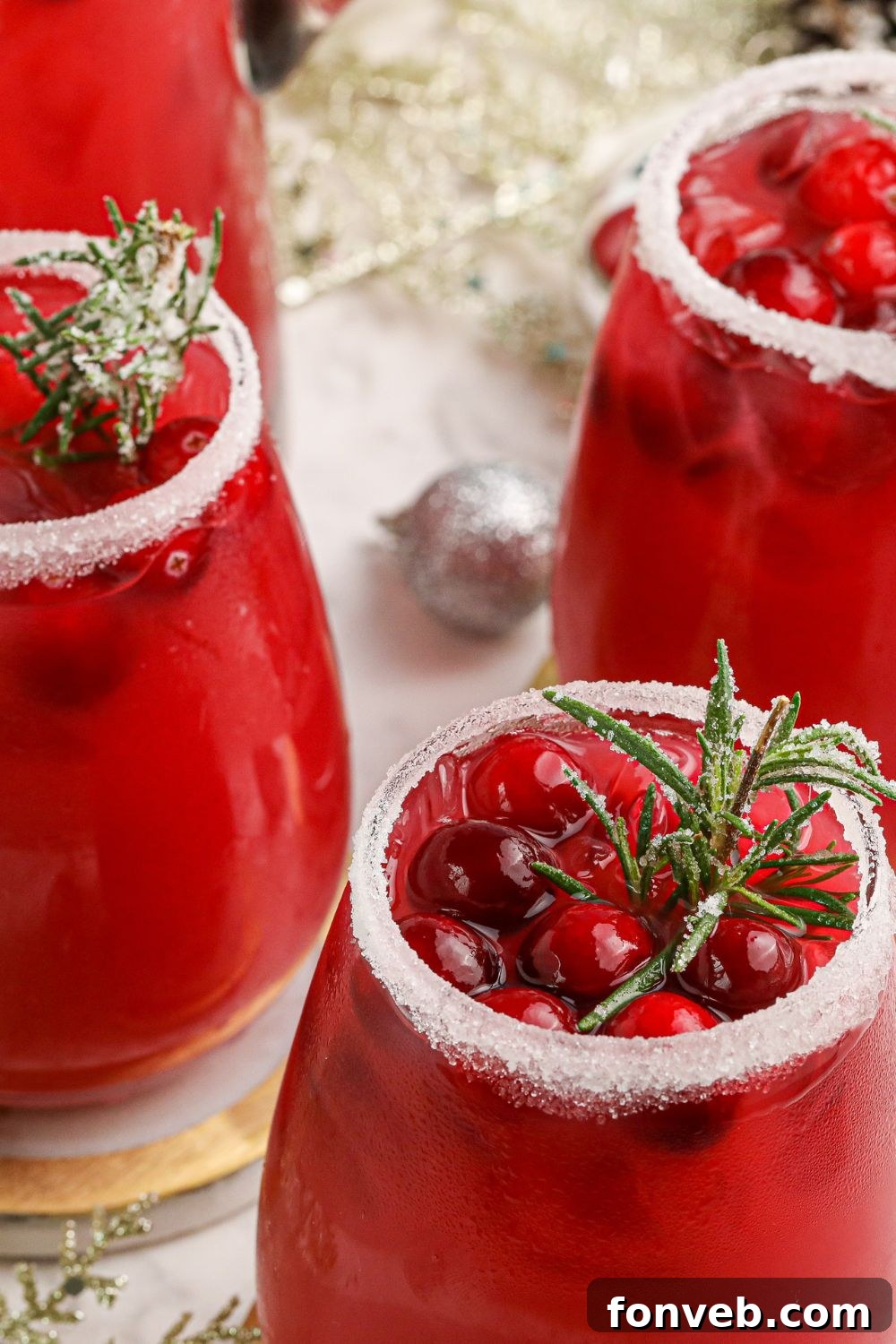 Mistletoe Magic Margarita 13 Orange cranberry cocktails in glasses, adorned with Christmas decorations around the table.