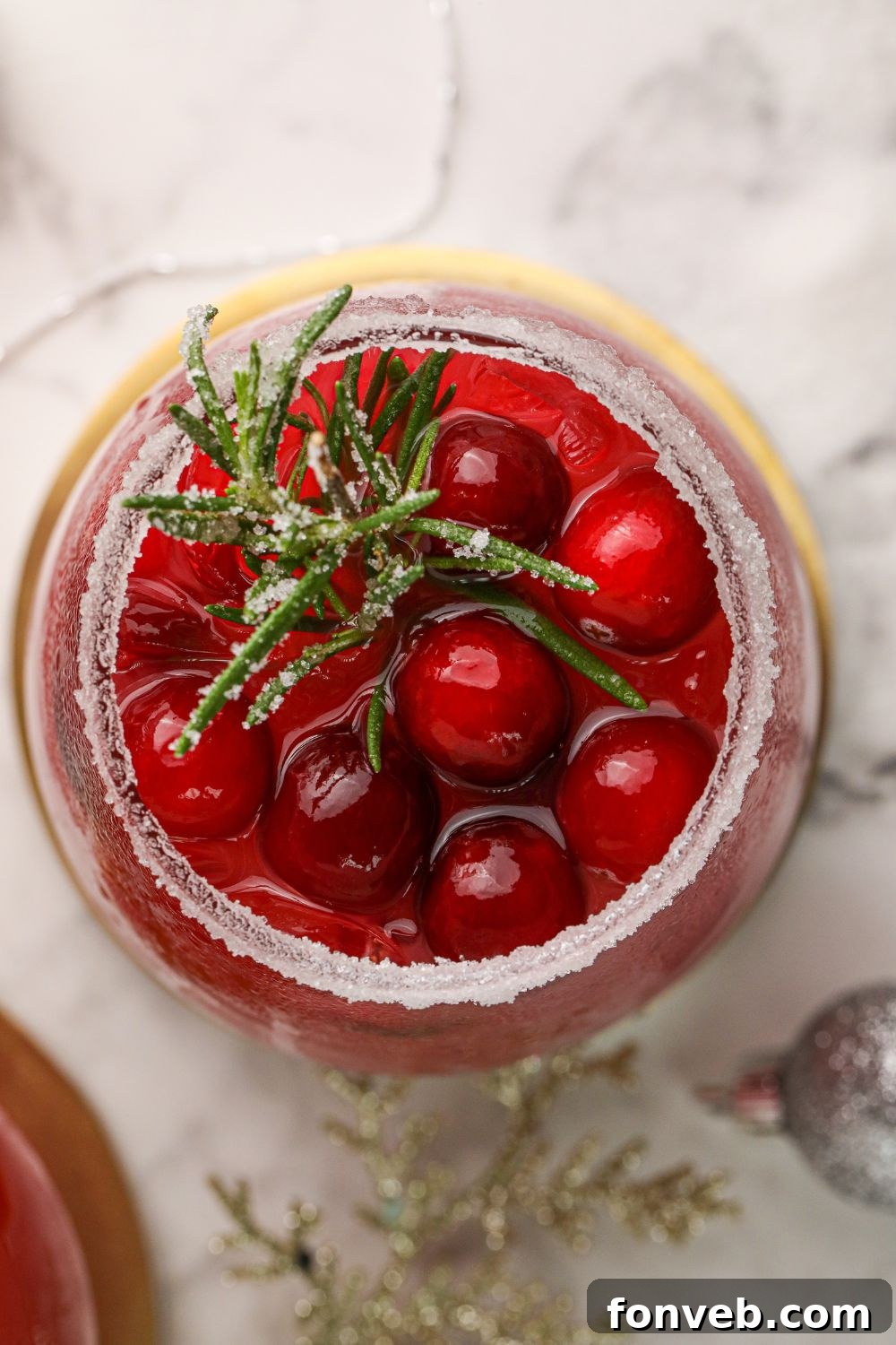 Mistletoe Magic Margarita 9 An overhead shot of a cranberry margarita in a glass on a sleek marble counter.
