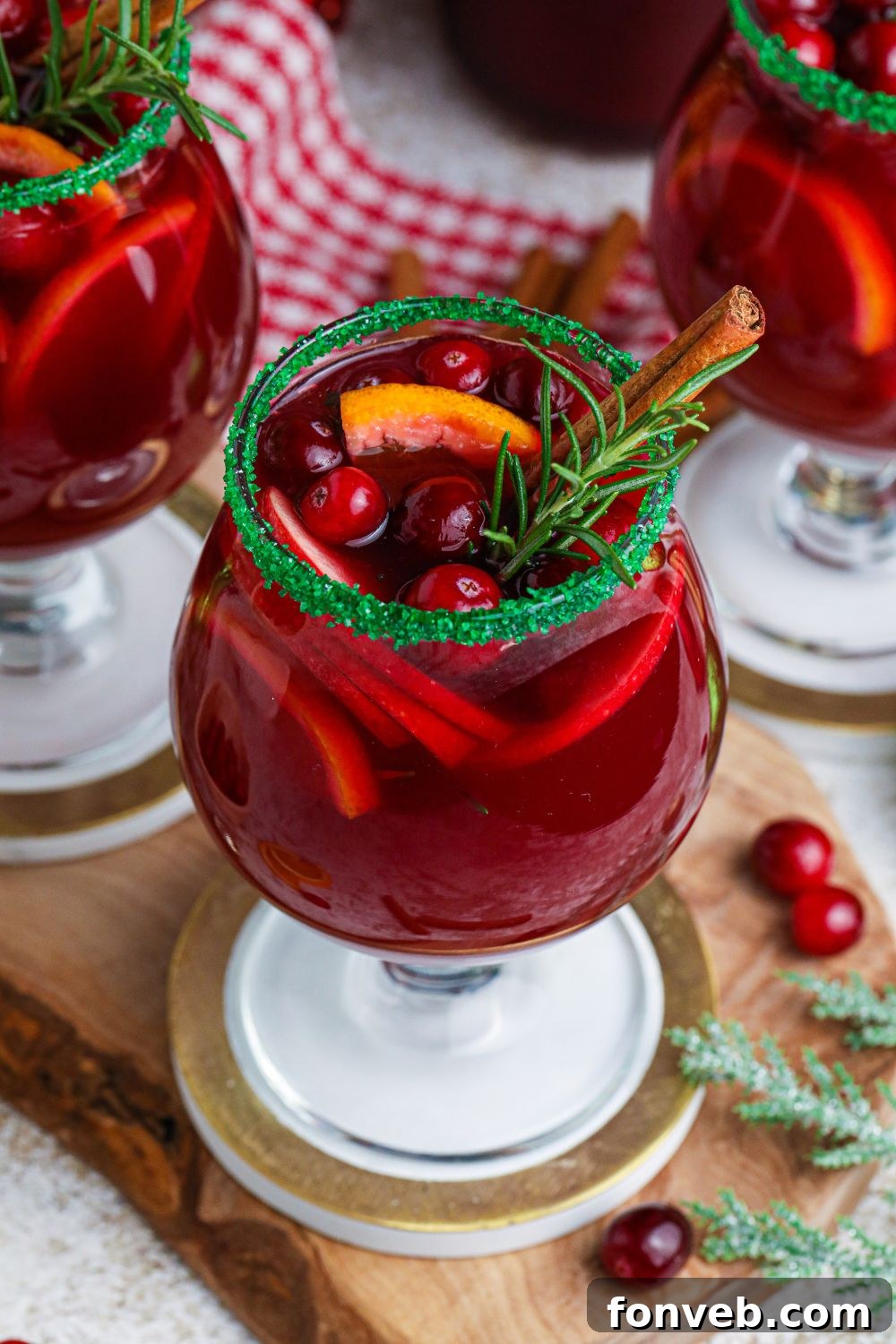 red wine cocktail with fruit on table with berries and herbs around it on table