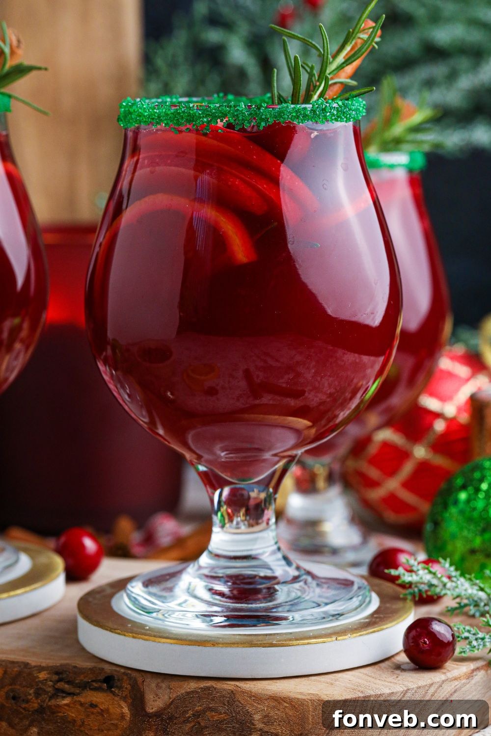 side view of glasses of Christmas cocktails sitting on coasters 