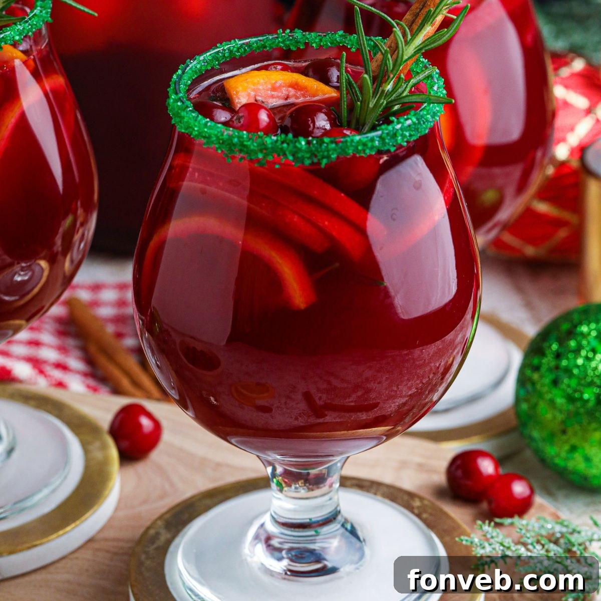 Christmas Sangria in glasses on table with cranberries and decorations around it