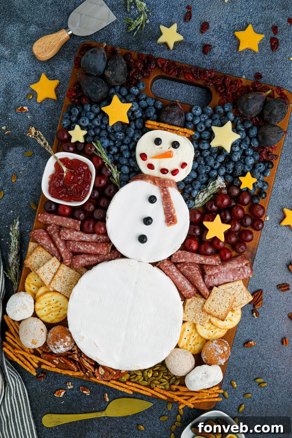 Close-up of winter themed snacks and fruits on the charcuterie board, including dark berries and nuts