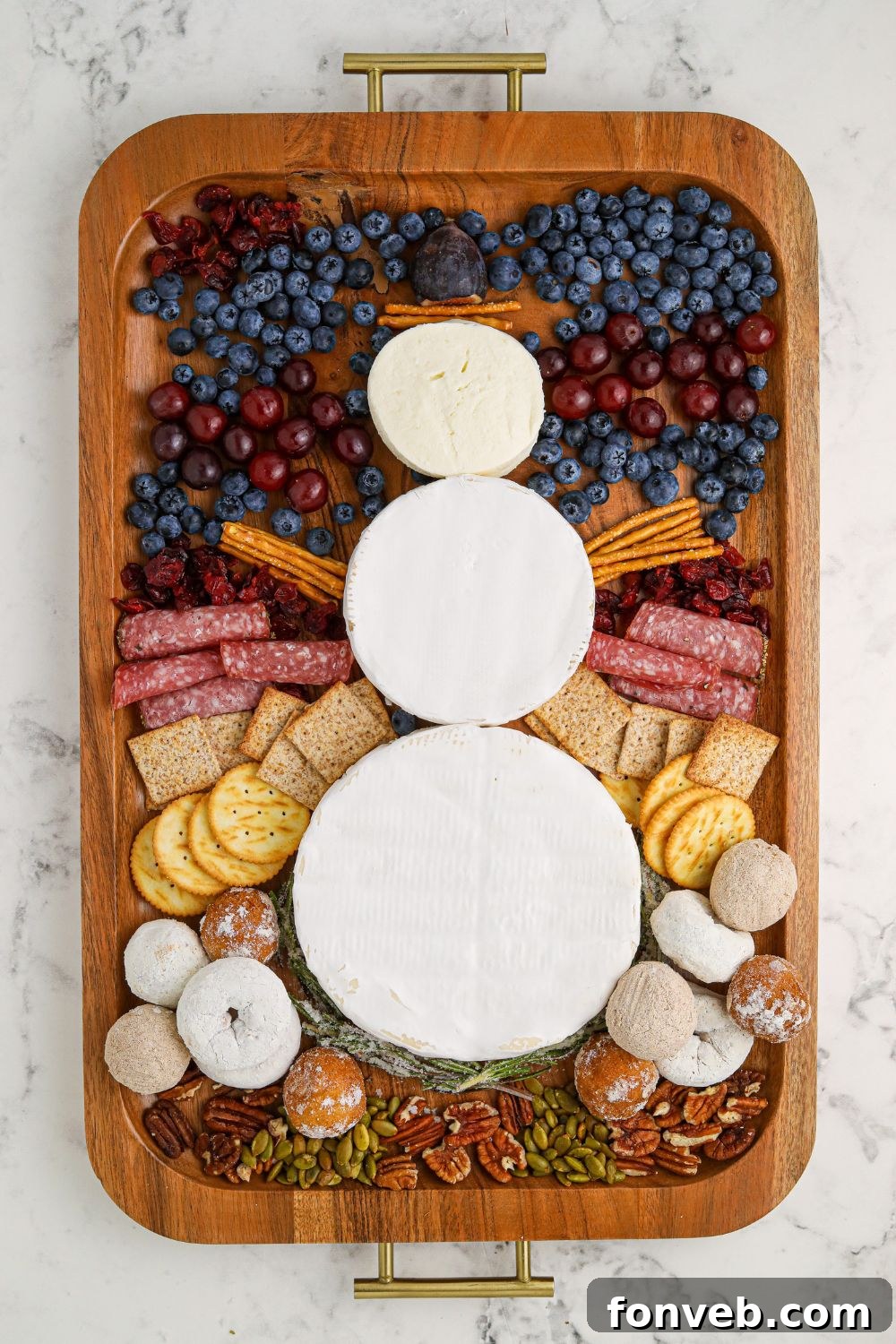 Step-by-step assembly of the Snowman Charcuterie Board, showing the snowman taking shape with facial features and hat