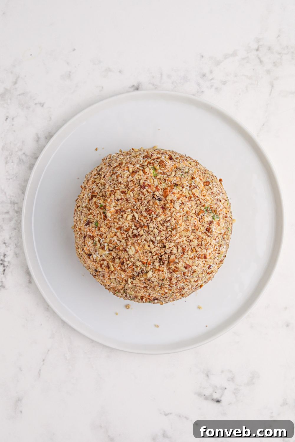 Rudolph's Holiday Charcuterie Platter 7 Cheeseball being rolled in finely chopped nuts