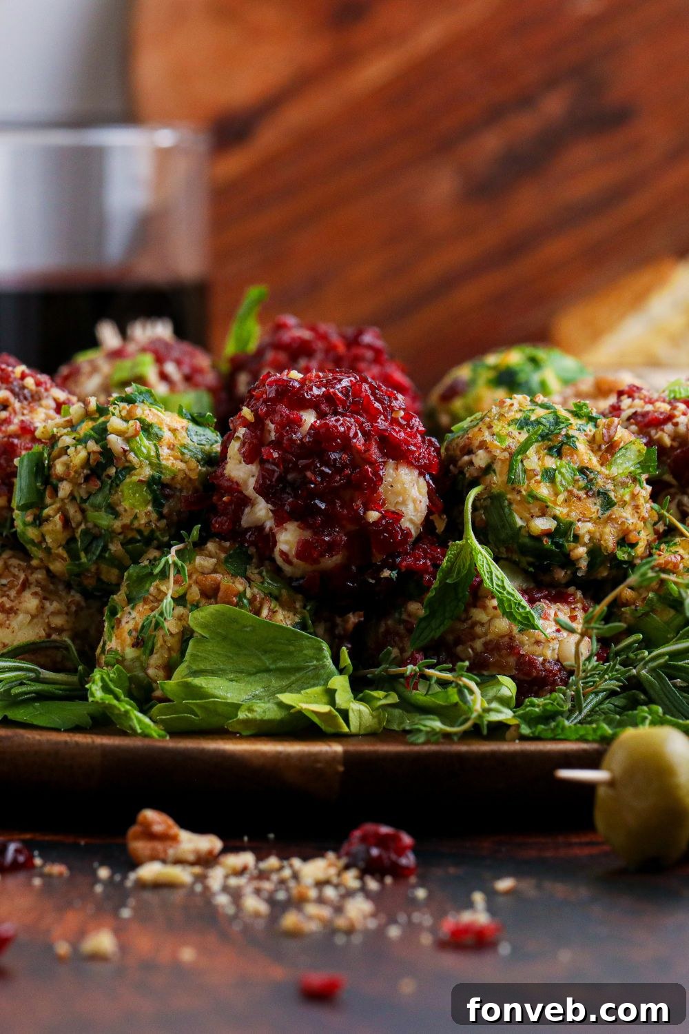Side view of the Cheese Ball Wreath with crushed nuts visible on the table, indicating its crunchy coating.