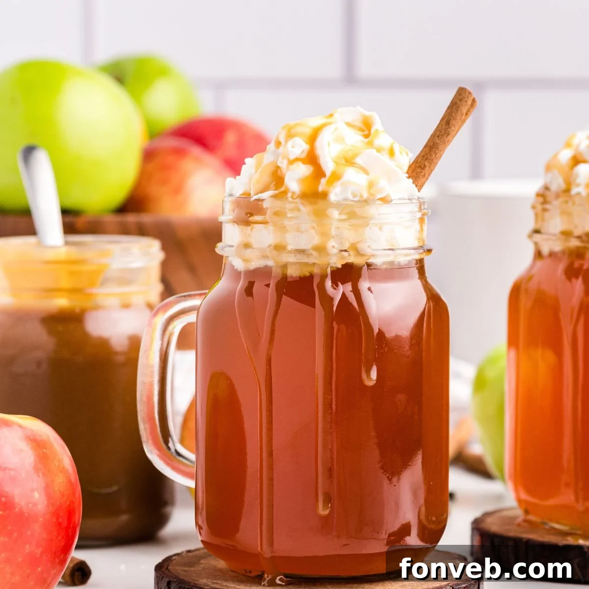 Cozy Caramel Apple Brew 2 A mason jar filled with steaming Crock Pot Caramel Apple Cider, topped with whipped cream and a drizzle of golden caramel syrup.