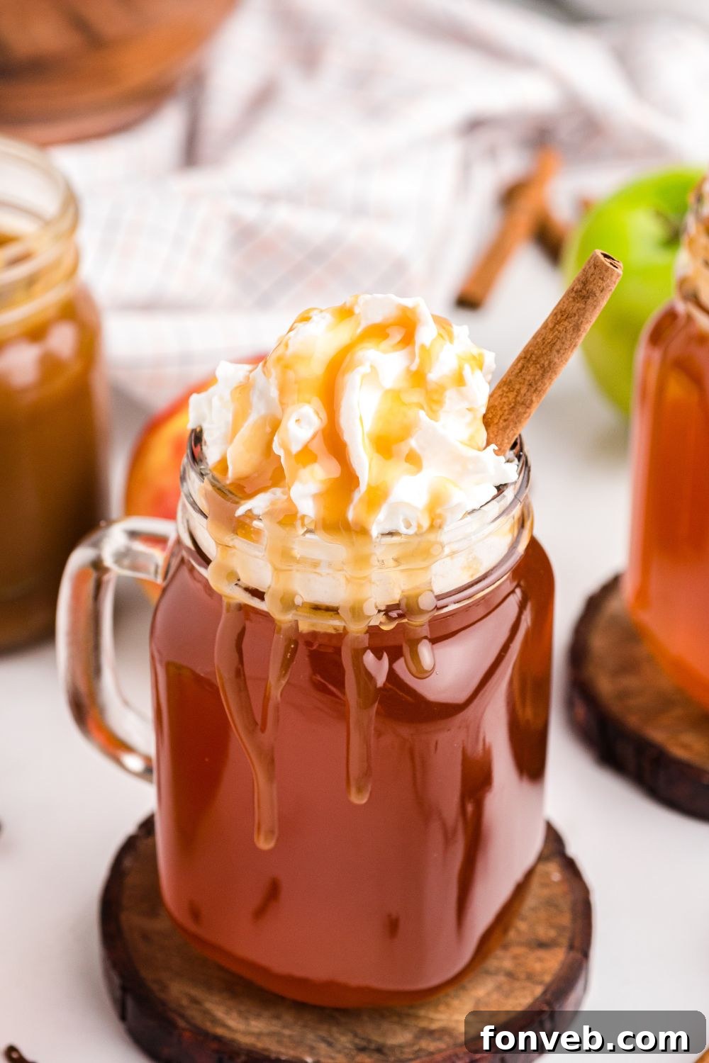 Cozy Caramel Apple Brew 16 Glasses of easy apple cider on a table, with fresh apples, creating a simple and inviting setup.