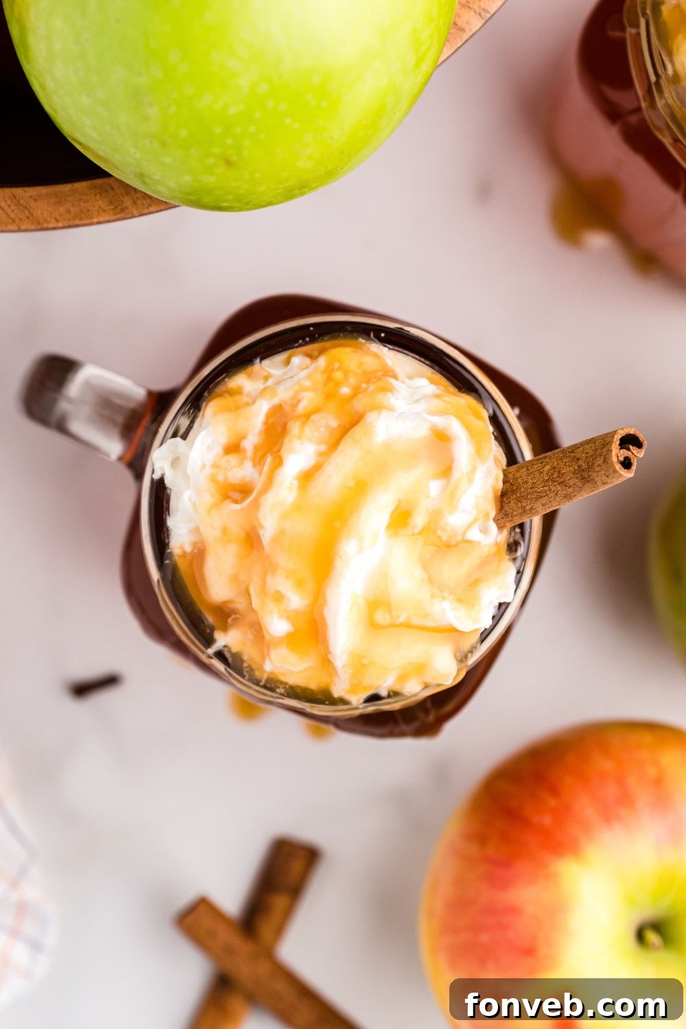 Cozy Caramel Apple Brew 4 An overhead shot of a cozy mug filled with amber-colored apple cider, steam gently rising.