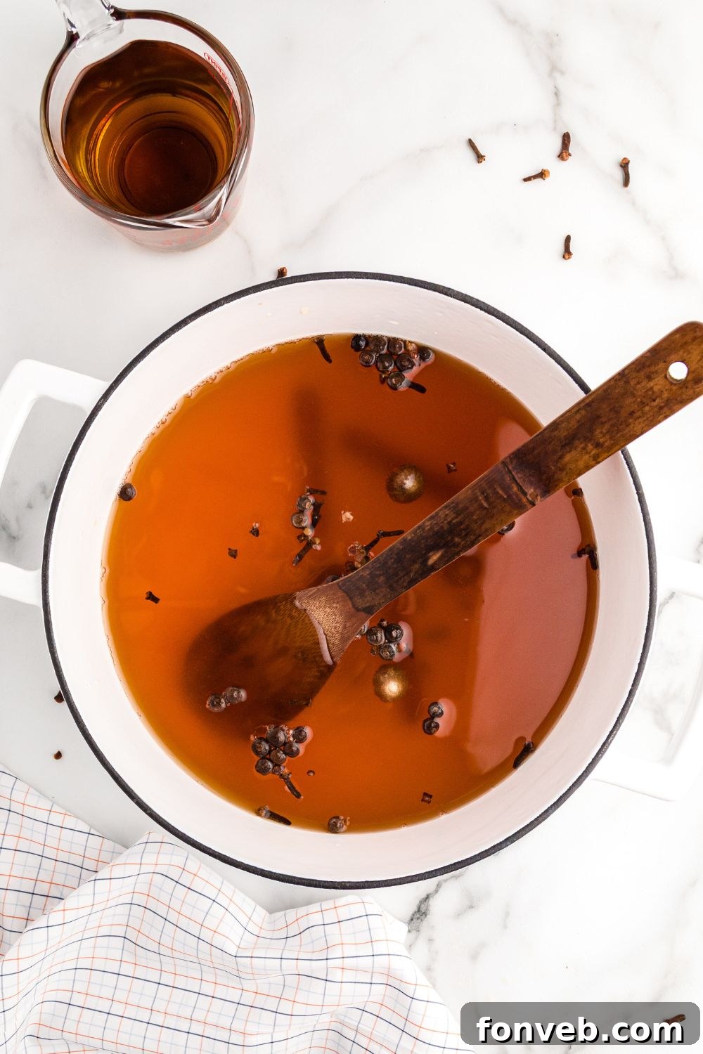 Cozy Caramel Apple Brew 7 A wooden spoon stirring a pot of warm apple cider, filled with spices and ready to be served.