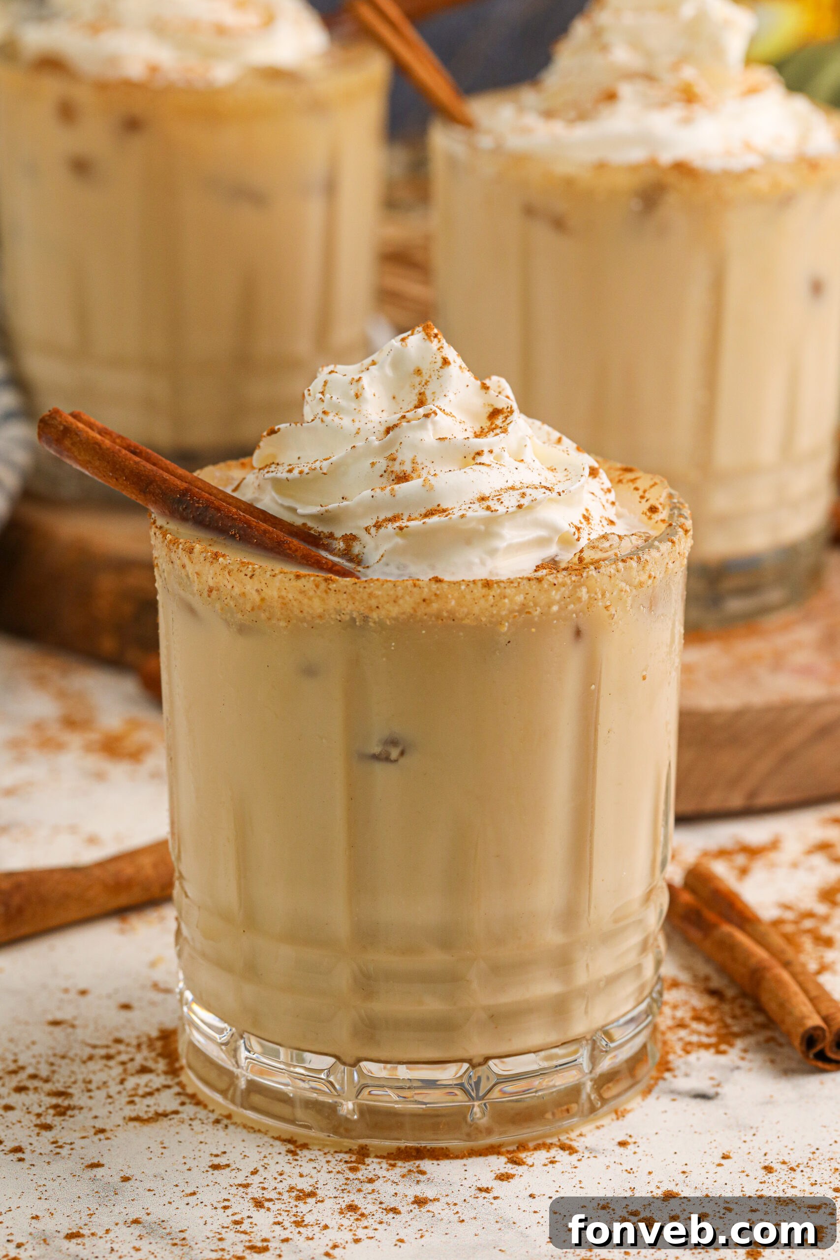 A beautifully presented pumpkin white russian cocktail in an elegant glass, resting on a clean white table, ready to be enjoyed.