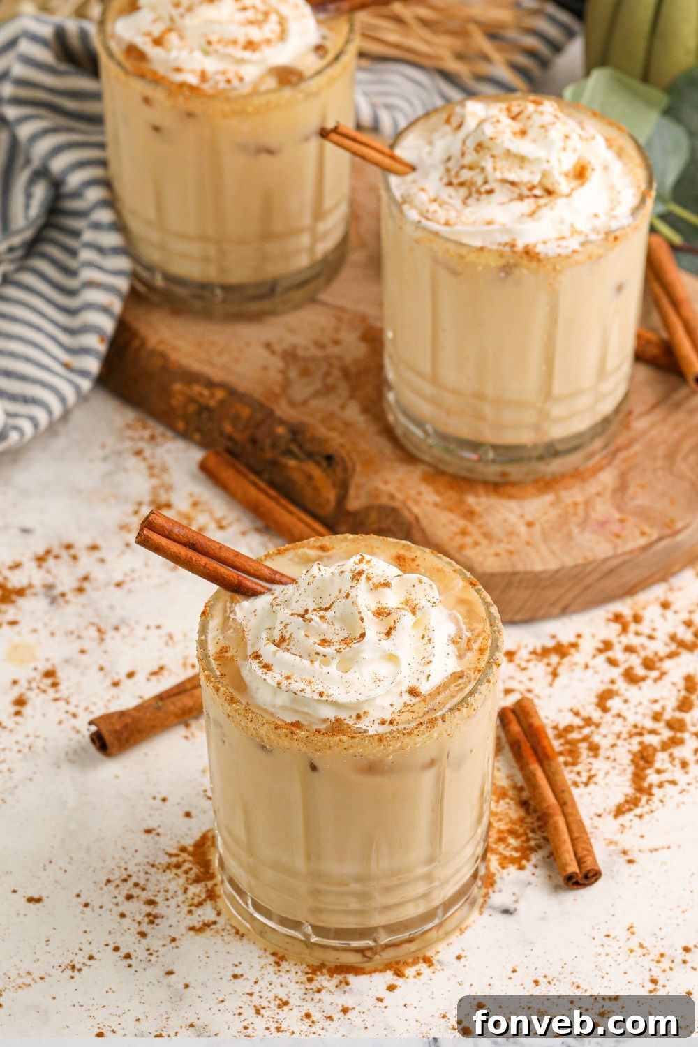 Multiple Kahlua cocktails arranged on a table, with cinnamon sticks scattered around the glasses, setting a warm and inviting mood.