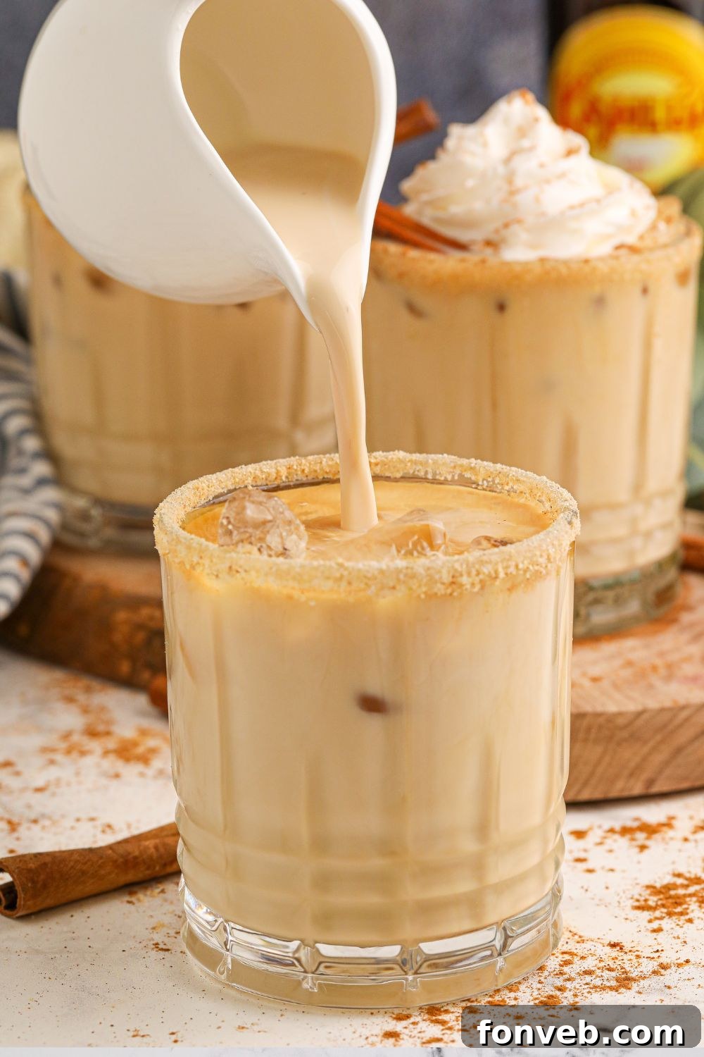A close-up view of the finished cocktail being topped with a dollop of creamy whipped topping.