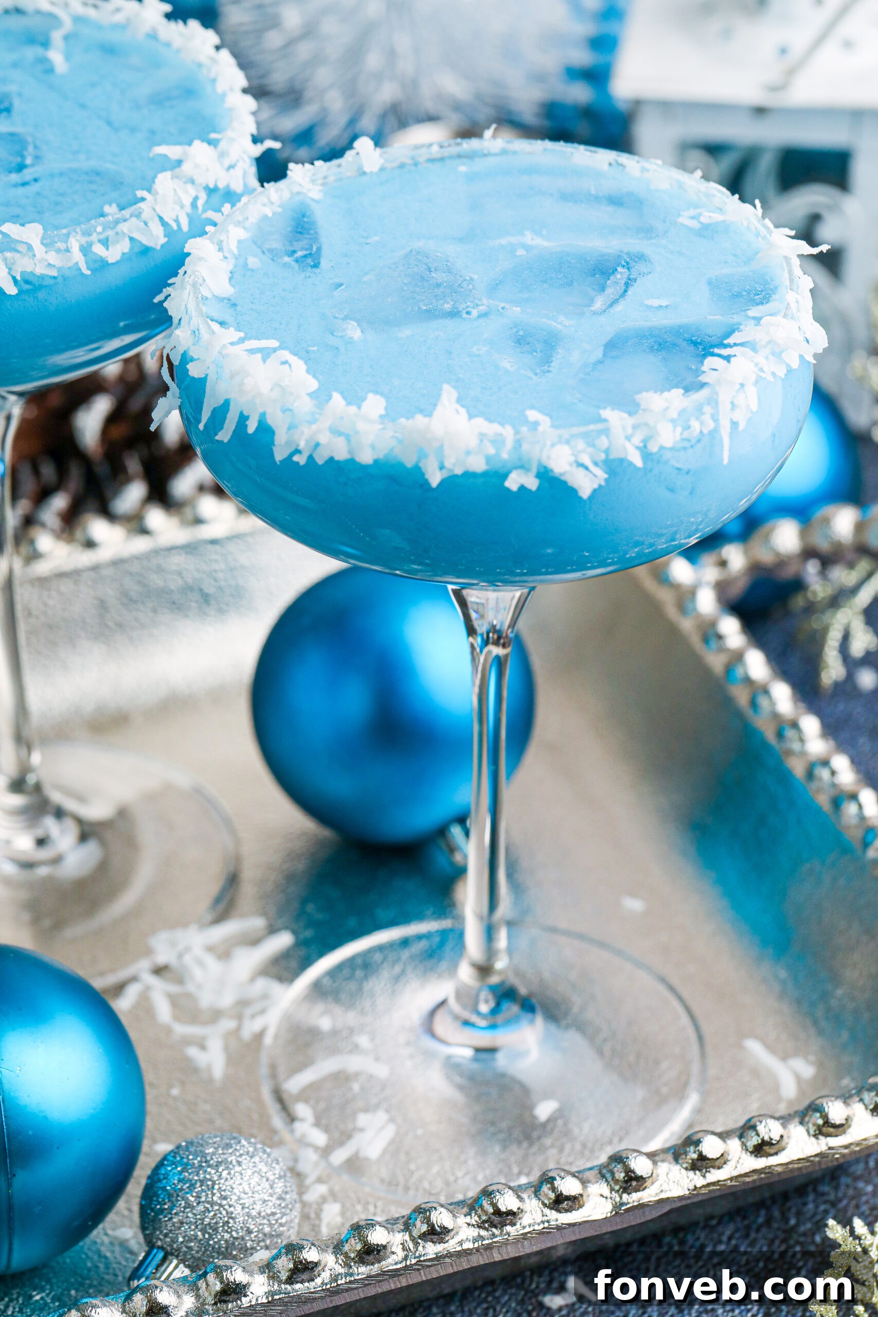 Vibrant blue Christmas cocktail with a coconut rim, exuding festive cheer