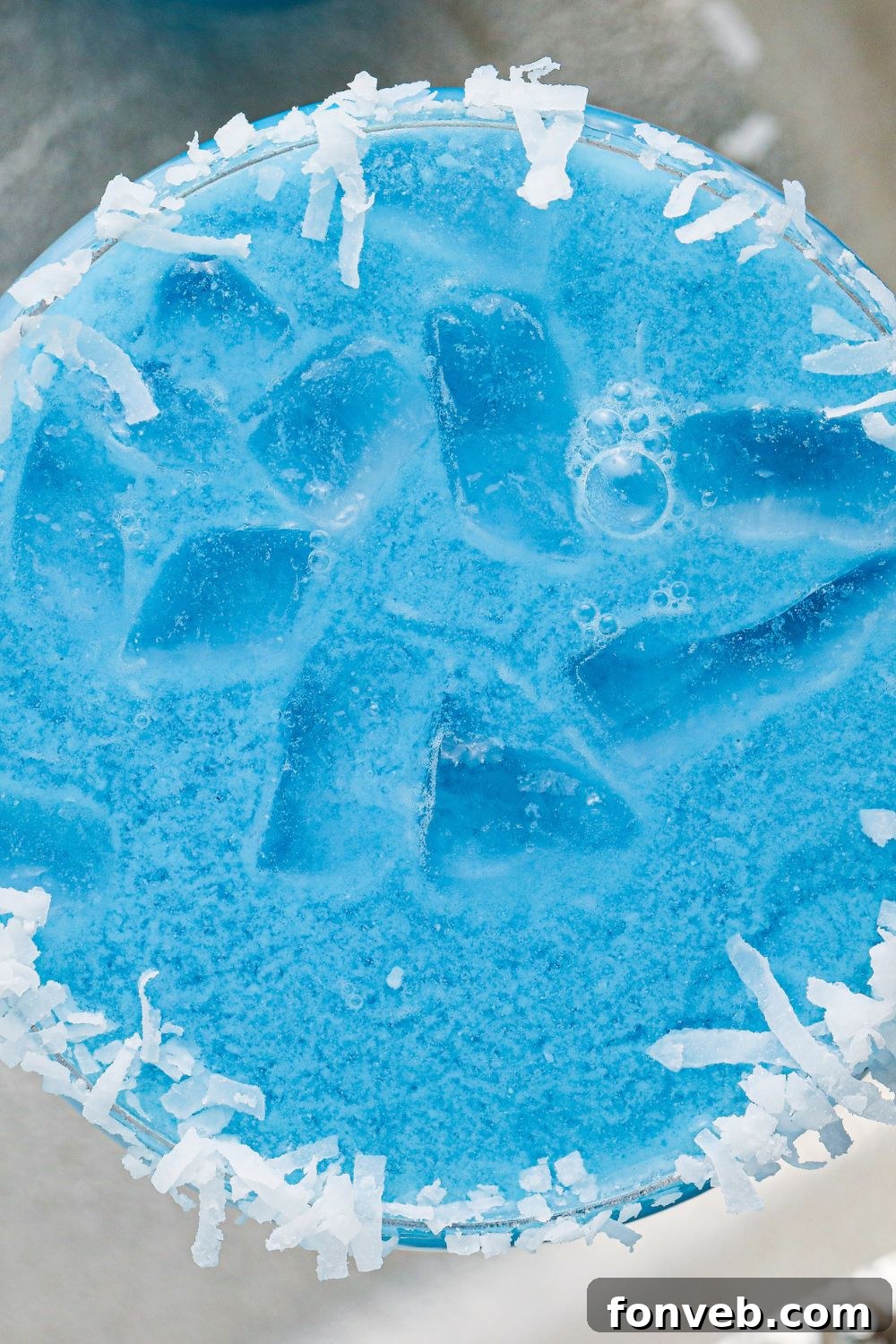 Overhead view of a perfectly crafted Blue Christmas Cocktail on a elegant table setting
