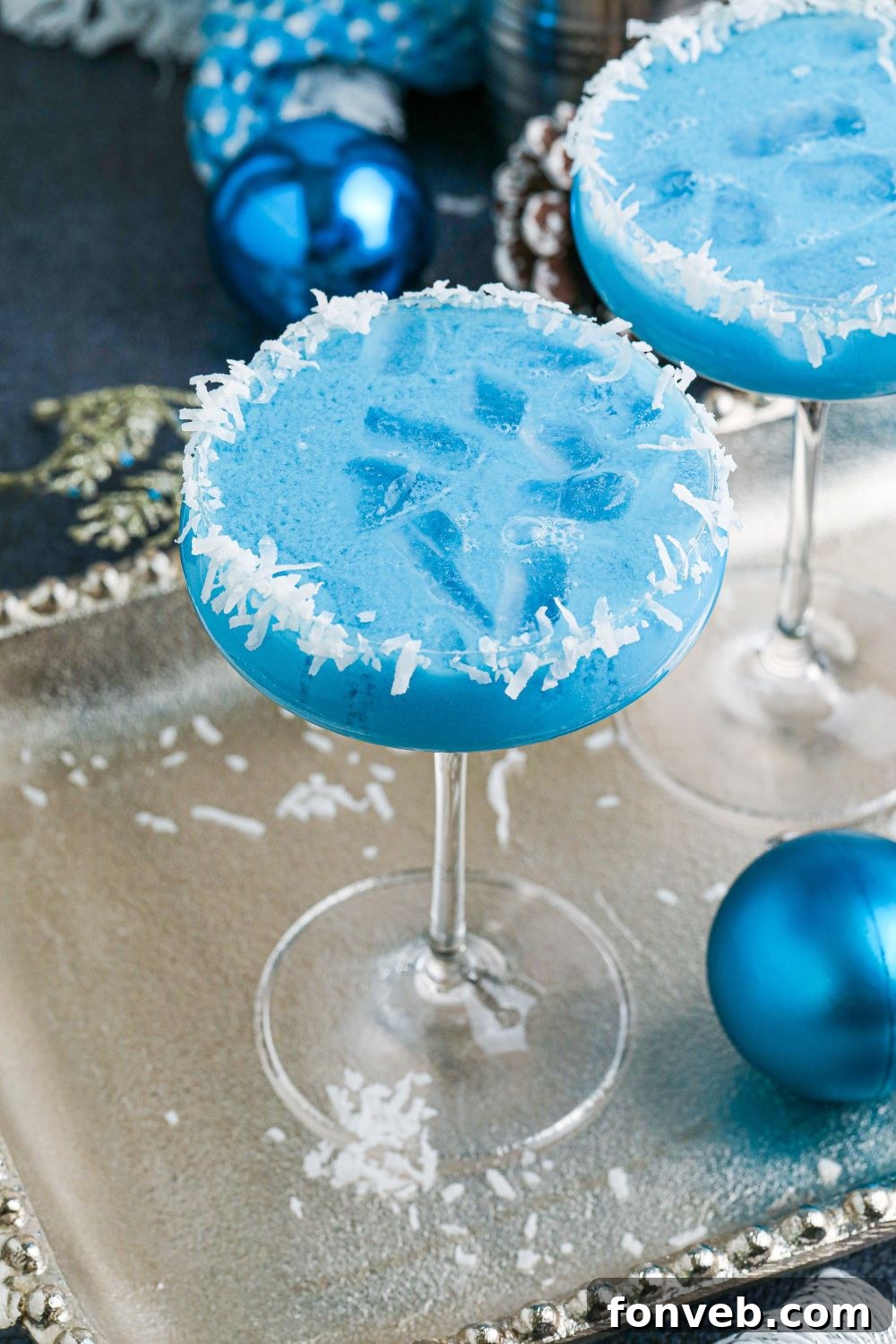 Festive Christmas cocktails on a silver platter, beautifully arranged with blue Christmas ornaments for a magical touch