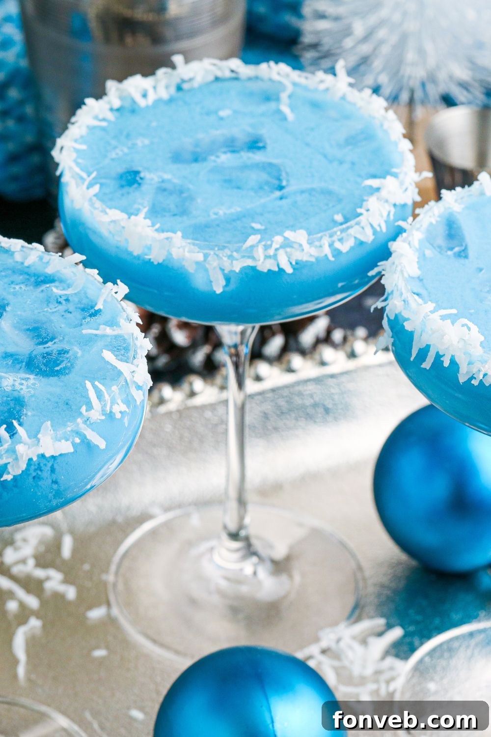 Elegant glasses filled with the luminous blue cocktail, arranged on a polished platter, awaiting guests