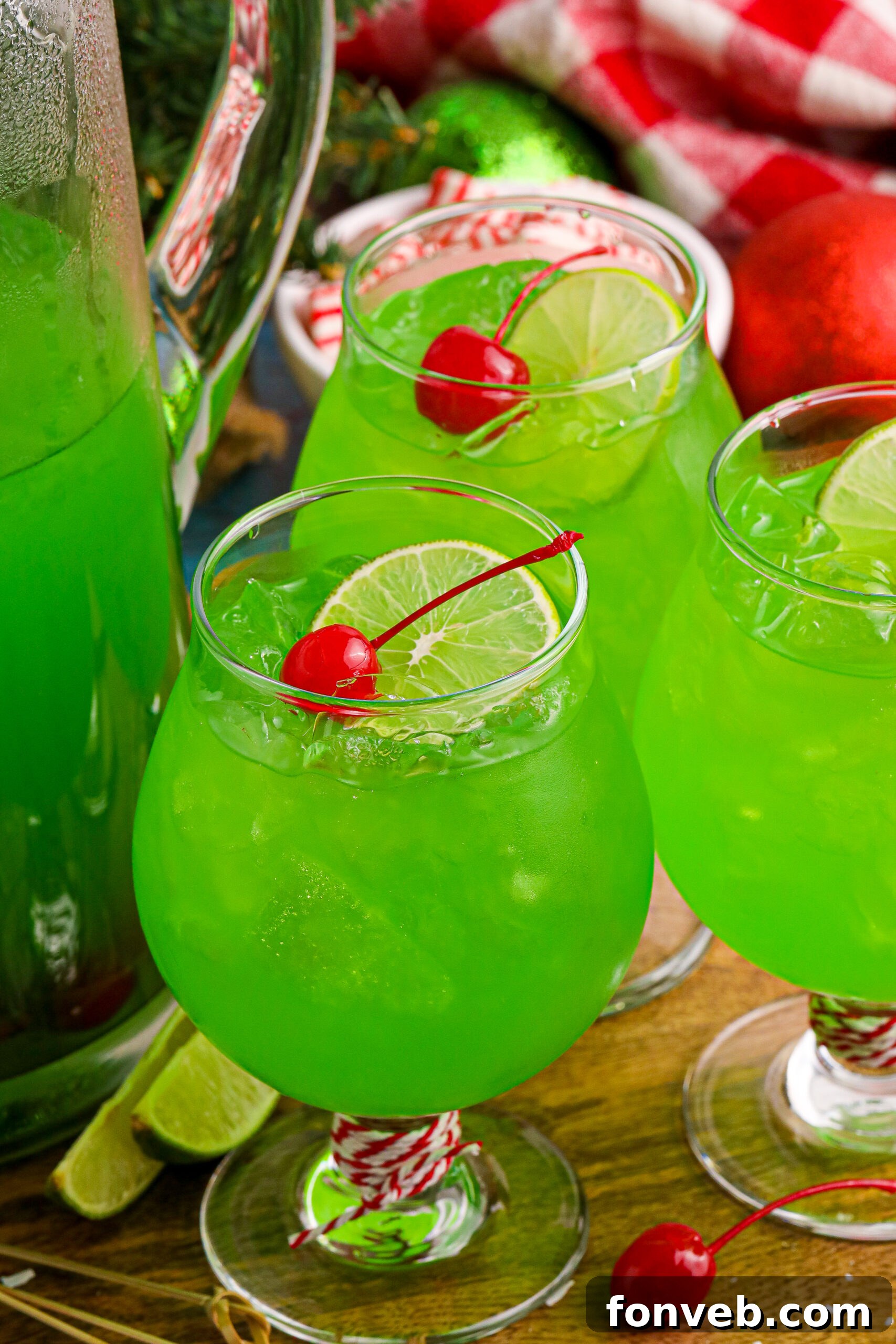Grinch Punch in a clear glass on a table with a cherry and a lime slice in the glasses 
