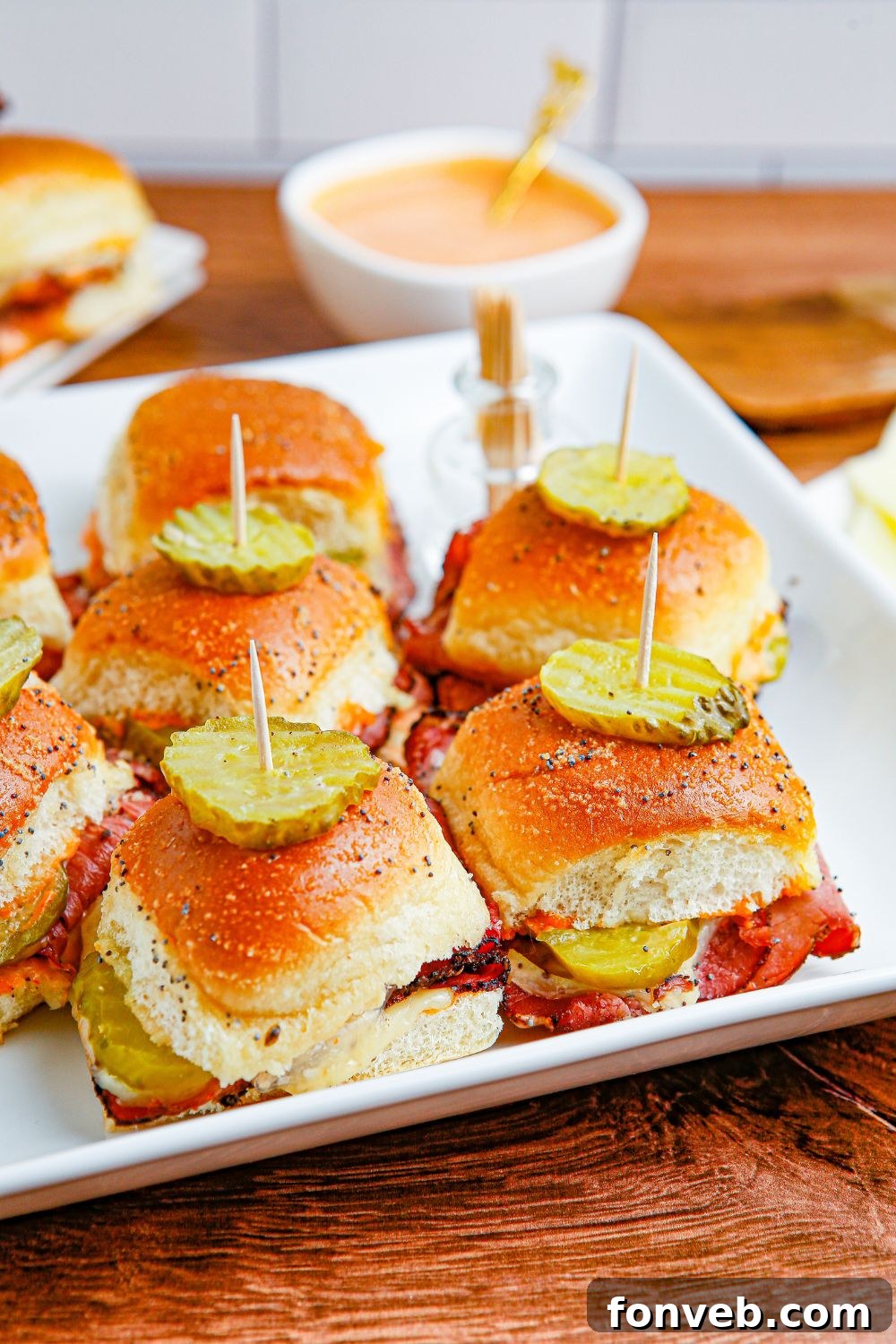 mini slider appetizer on tray with sauce behind it in bowl 