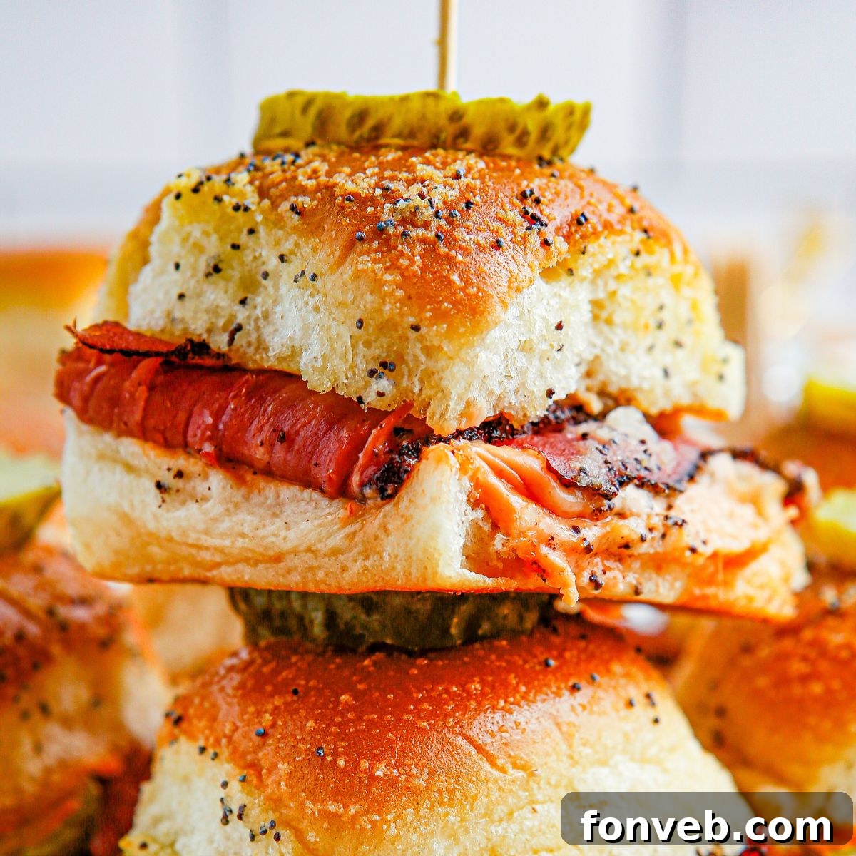 Pastrami Sliders stacked on table with toothpick in the center 
