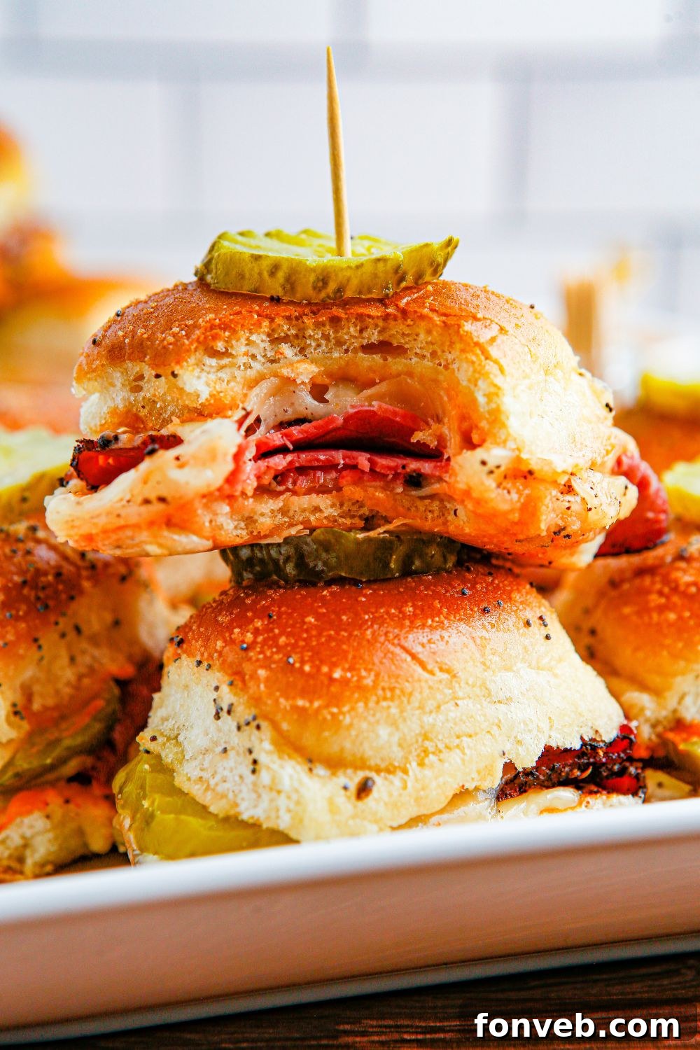 pastrami sliders on hawaiian rolls stacked on plate