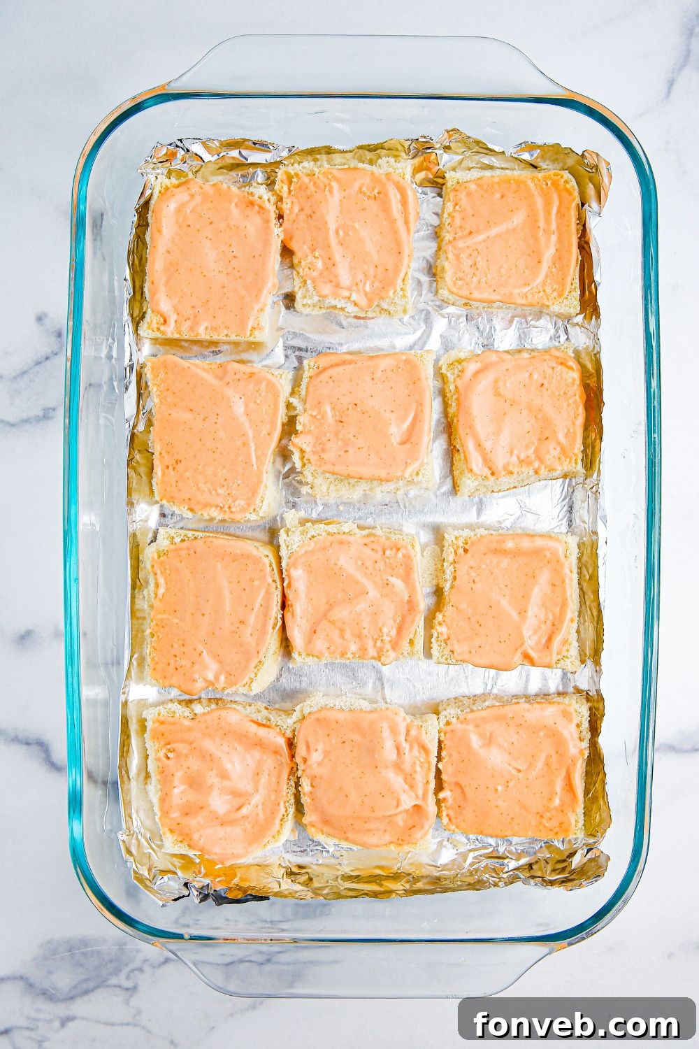 slider buns with sauce on top of each roll 