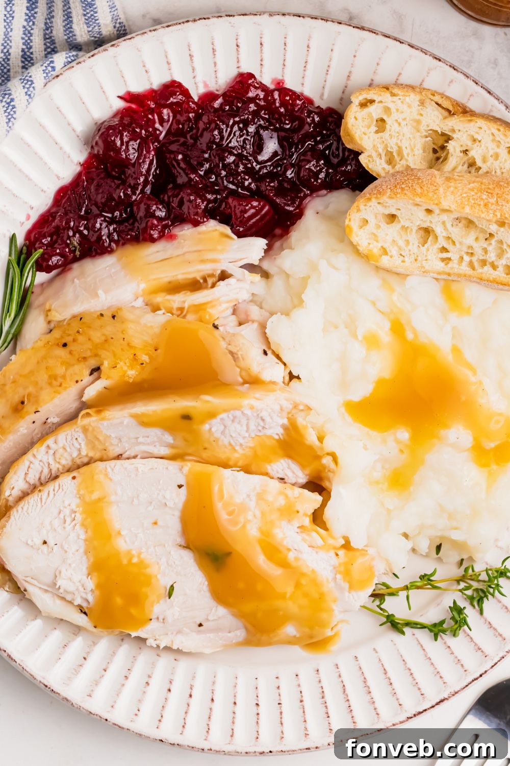 plate loaded with turkey, potatoes, cranberry, and bread