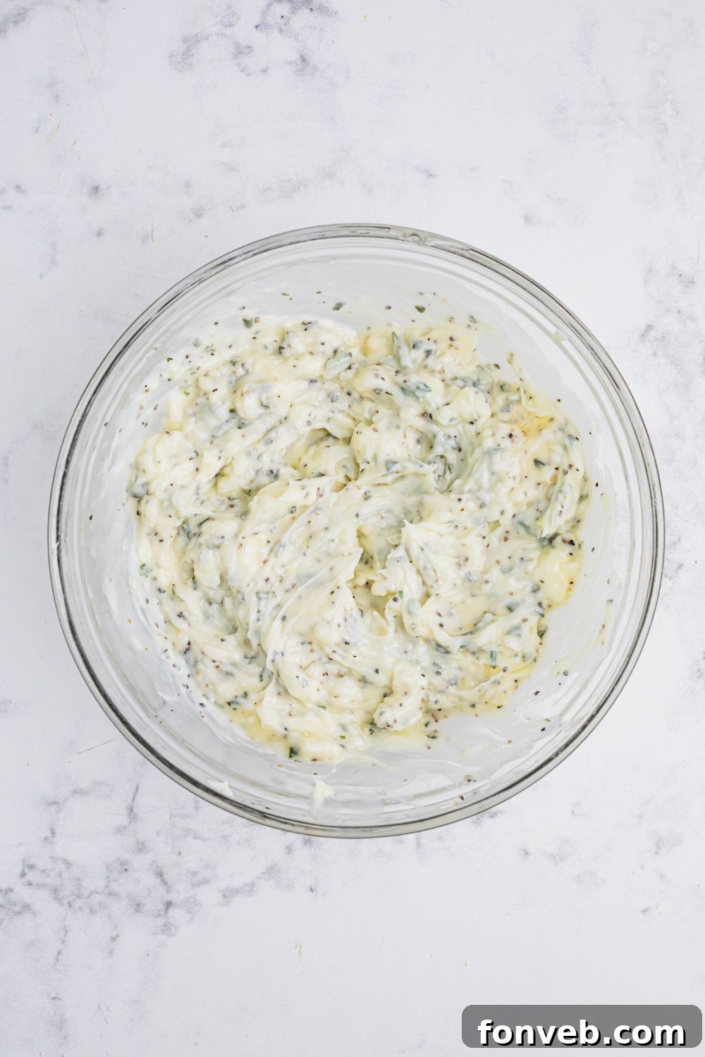 herb butter mixed together in a glass bowl on table 