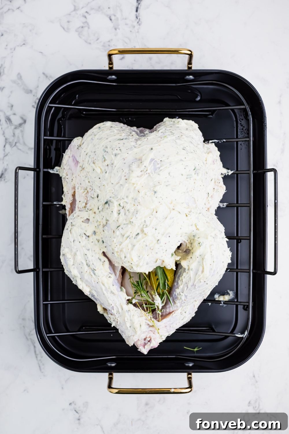 butterball turkey slathered with butter in a roasting pan 
