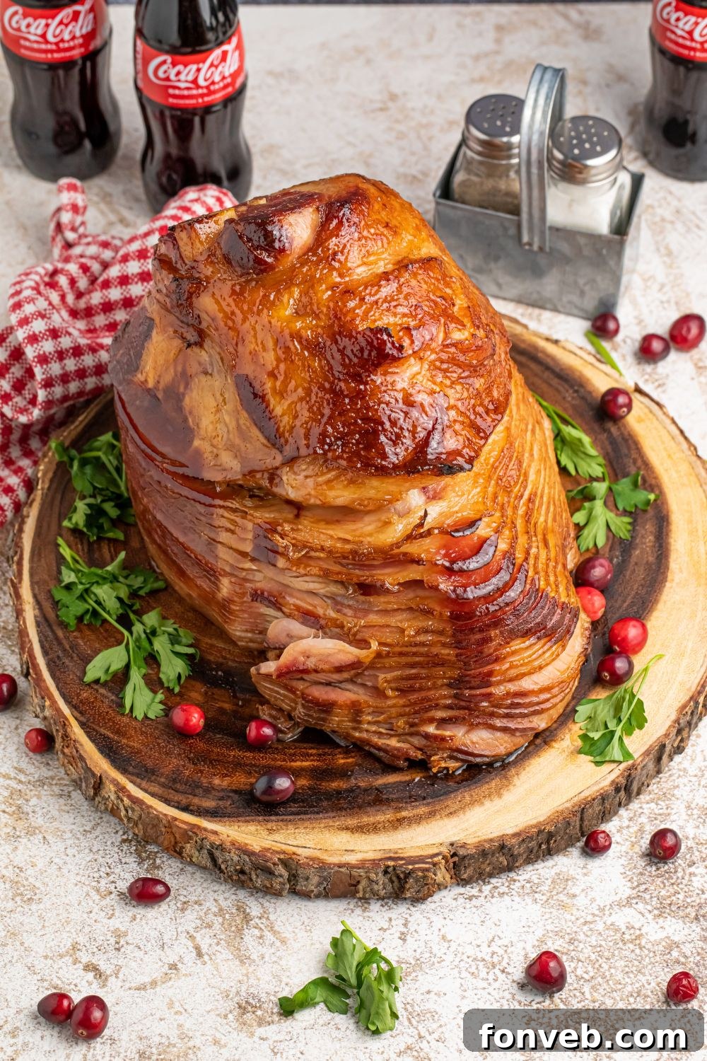 side overhead view of ham on platter with cranberries around the platter