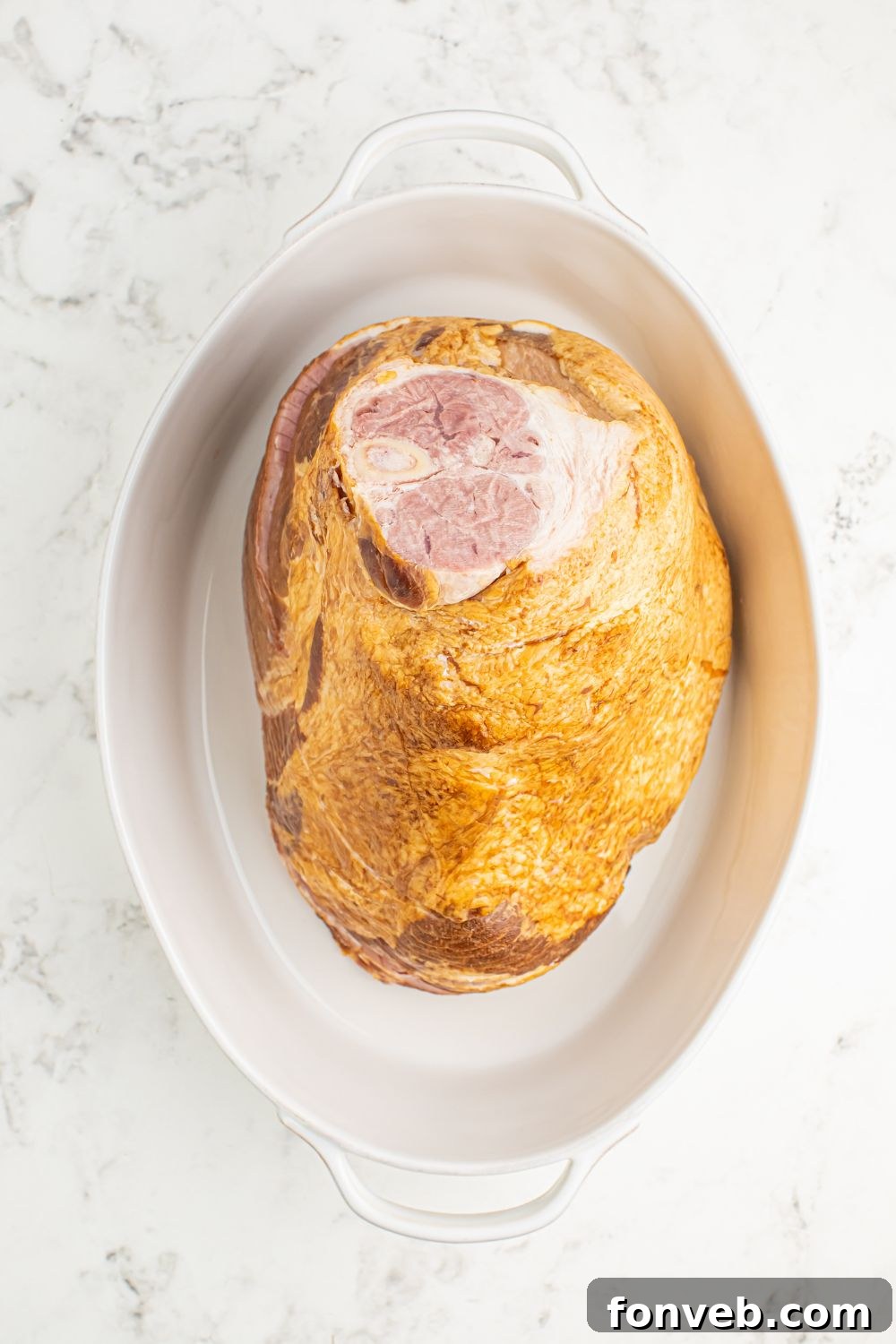 raw ham in a baking dish on table