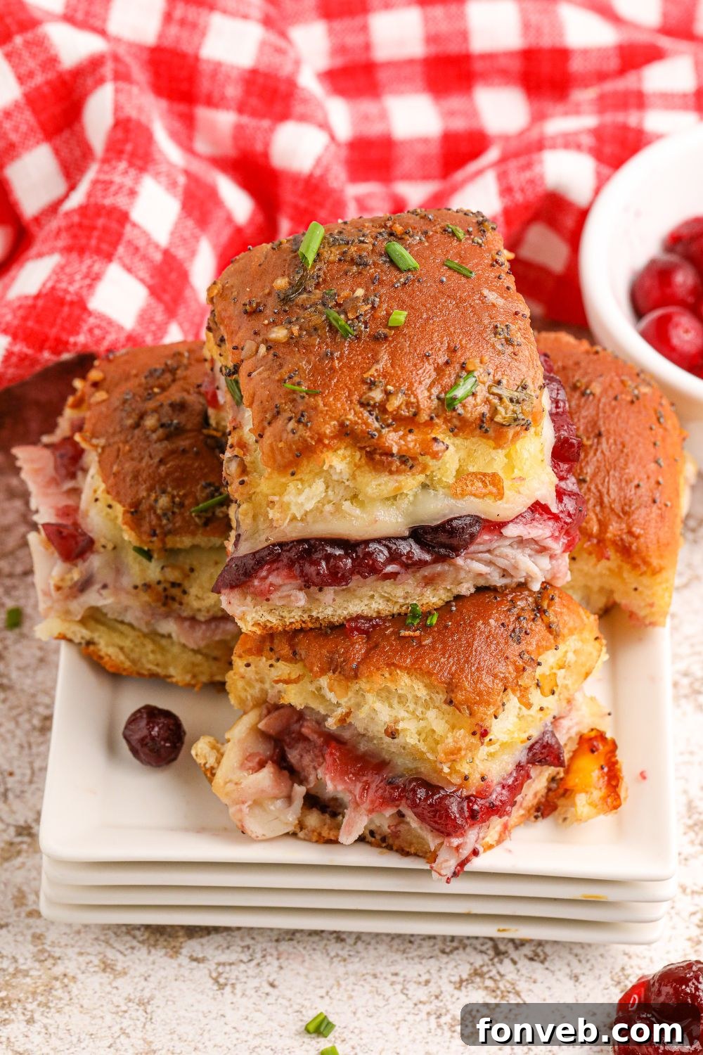 Close-up of turkey sliders on a plate with a napkin, highlighting the golden buns and visible fillings