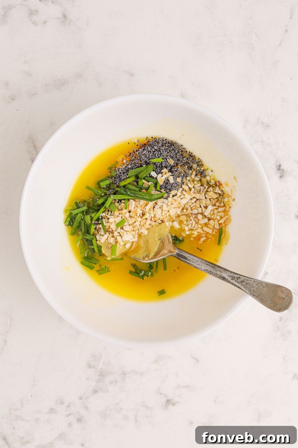 bowl with melted butter and various herbs and spices mixed for the slider topping